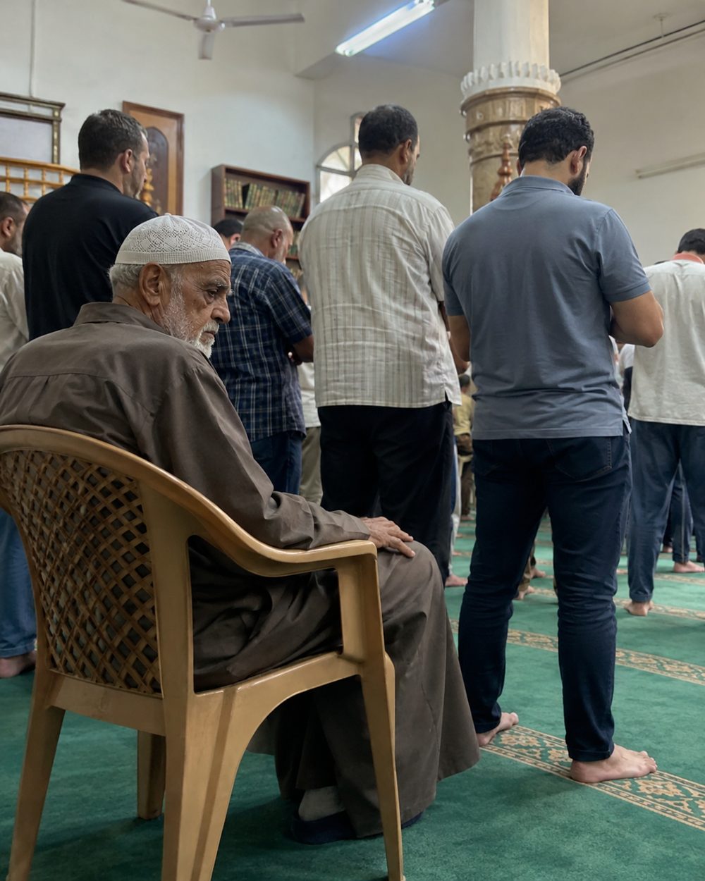 راجل كبير بيصلي على كرسي في الجامع